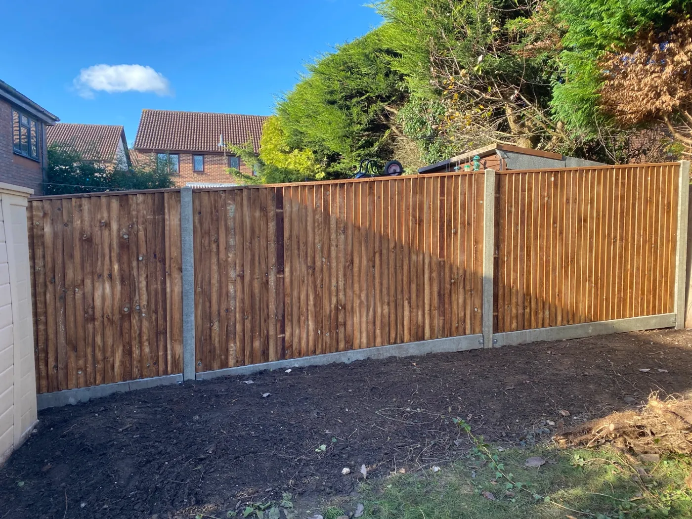 New closeboard fence with concrete posts and gravel boards in a garden